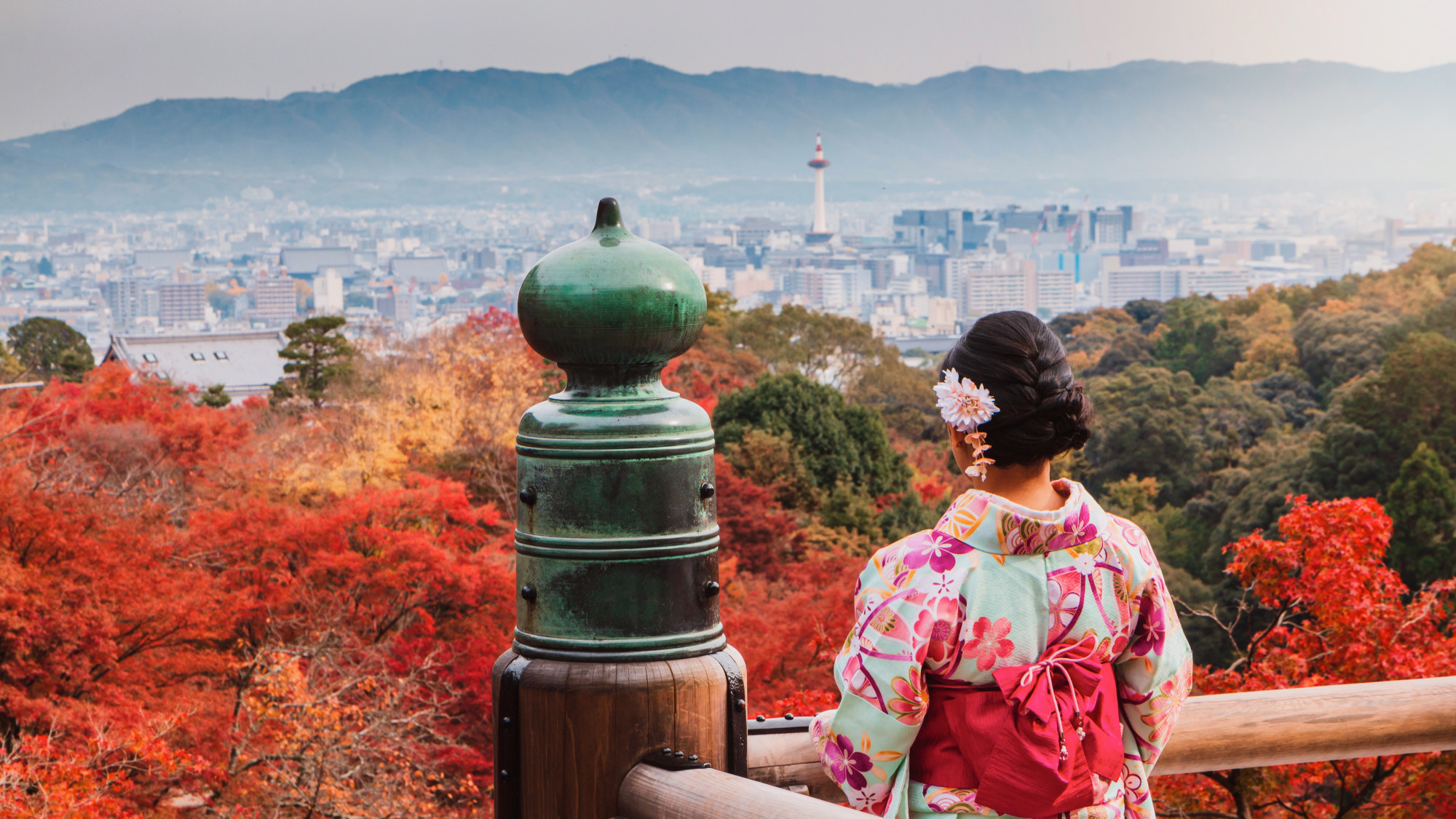 Asian woman wearing beautiful kimono walking and travel in the japanese garden inside the temple with red maple leaves in the autumn. Premium Photo